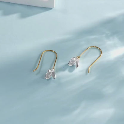 Gold hook earrings with delicate silver flower bud drops.


