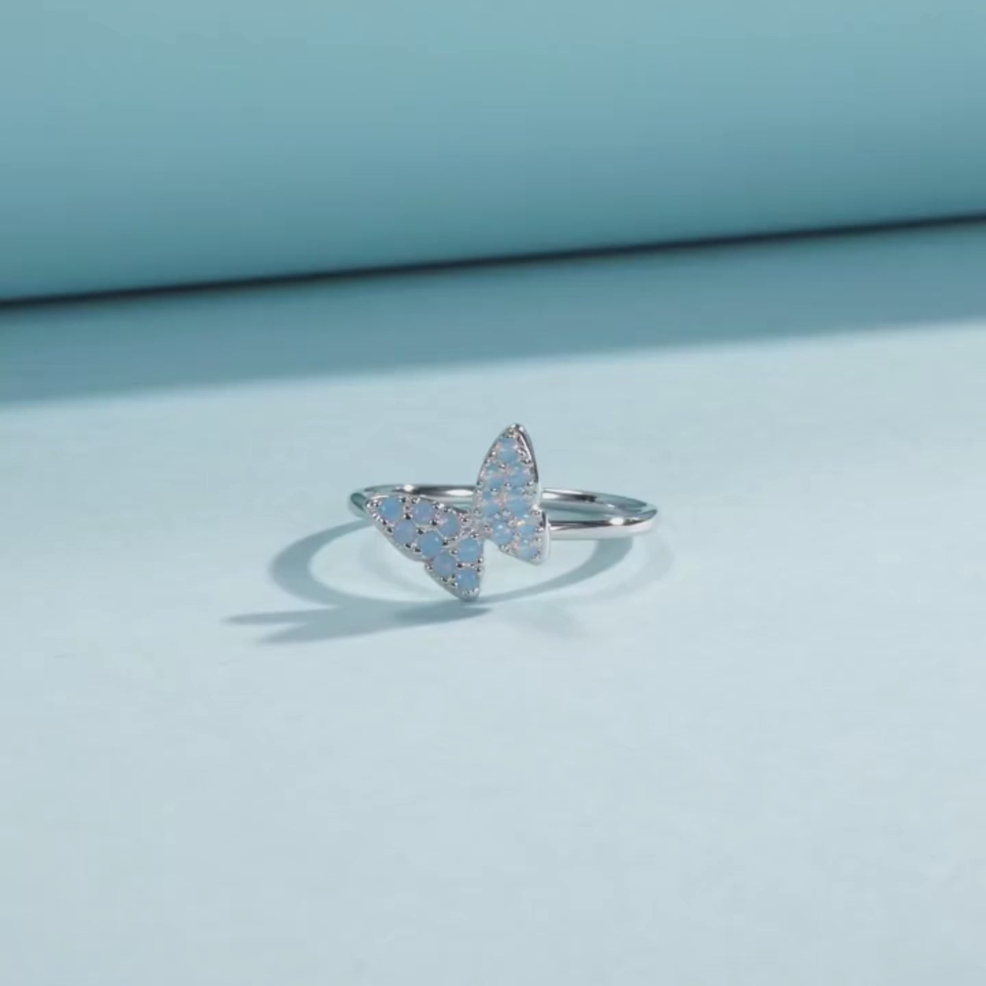 Sterling silver ring with a delicate butterfly shape inlaid with shimmering opal stones

