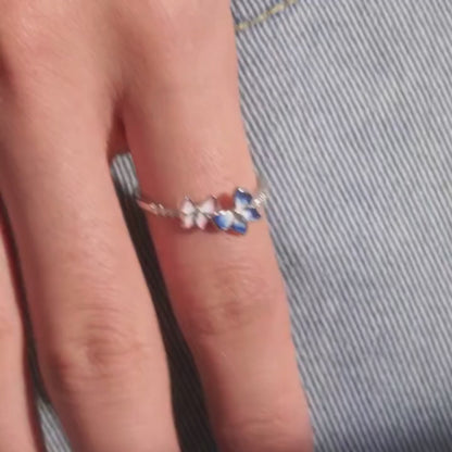 Delicate silver ring with pink and blue enamel butterflies and small white stones

