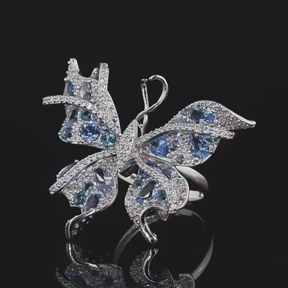 Silver butterfly-shaped ring with shimmering light blue and aqua gemstones set in detailed wing patterns

