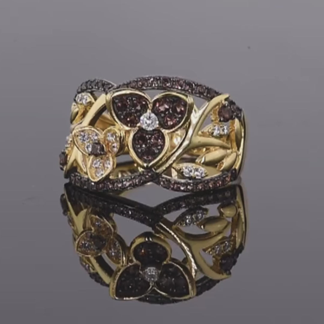 Gold-toned ring with dark butterfly and branch design, accented by brown and white stones


