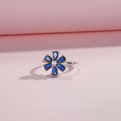 Sterling silver ring with a royal blue gemstone flower and clear stone center

