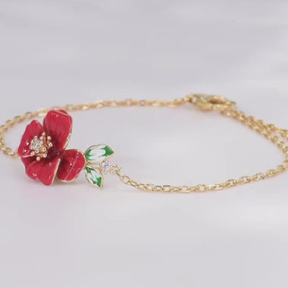 Delicate gold bracelet featuring a red enamel flower with a crystal center and green-and-white enamel leaves, Rosa Rossa from the Rossa Collection.

