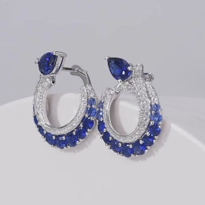Sterling silver hoop earrings with pavé and deep blue pear-shaped sapphires.

