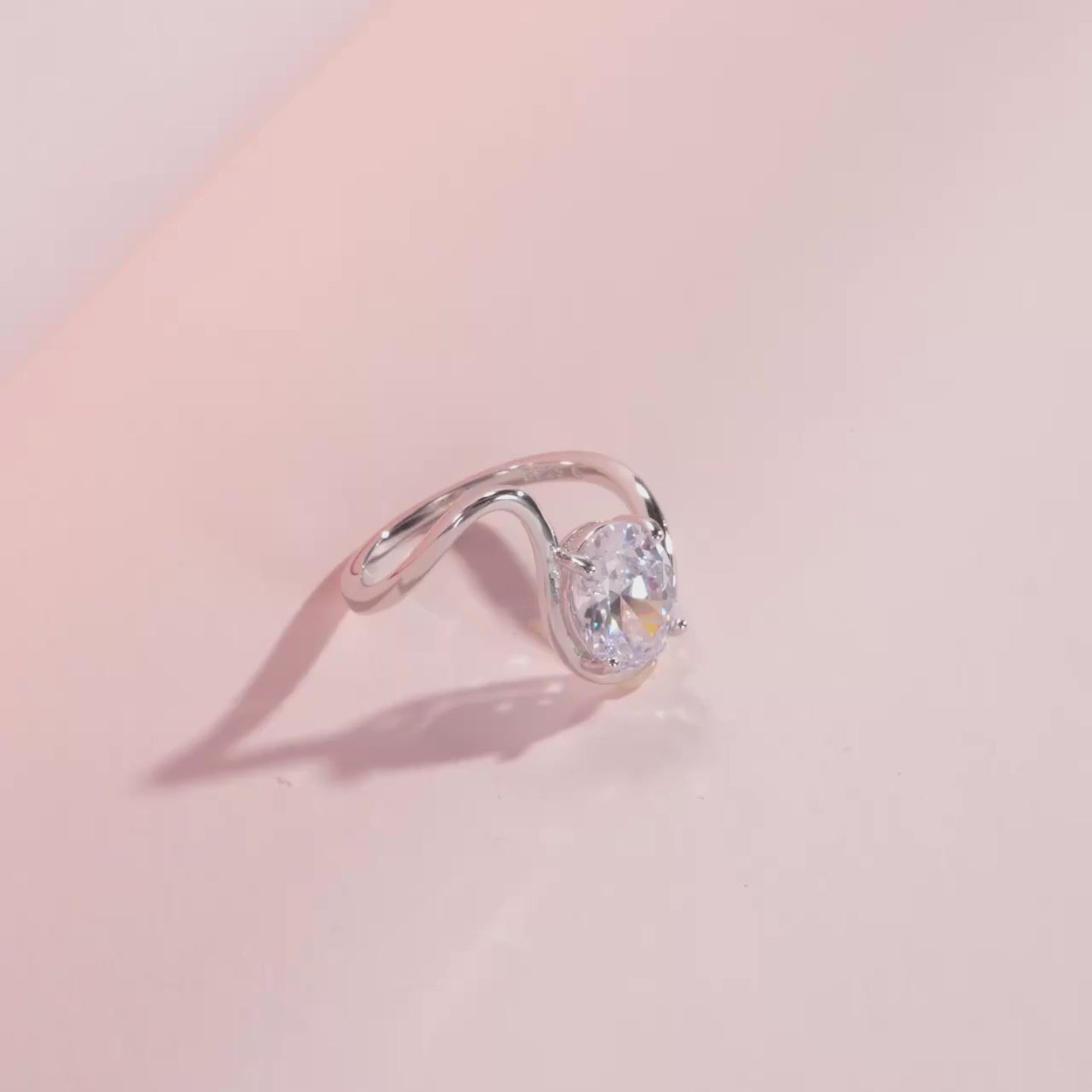 Open silver ring with a triangular wrap design, featuring a prominent oval white stone at its center, from the Bianco Nero collection.

