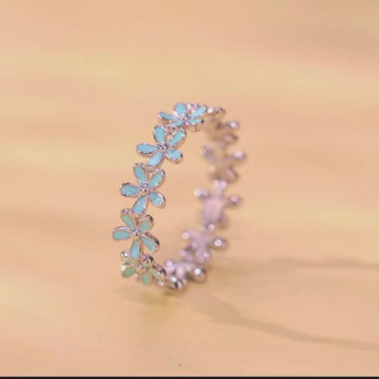 Silver floral band ring with alternating blue enamel and plain silver daisy motifs

