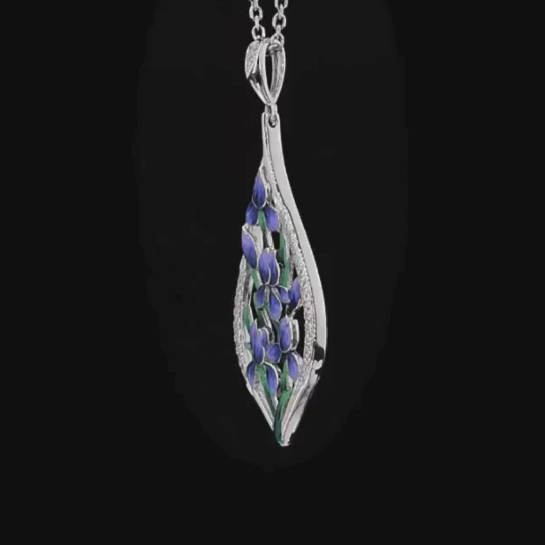 Silver pendant featuring blue and violet enamel flowers with green leaves, framed by a teardrop of pavé stones

