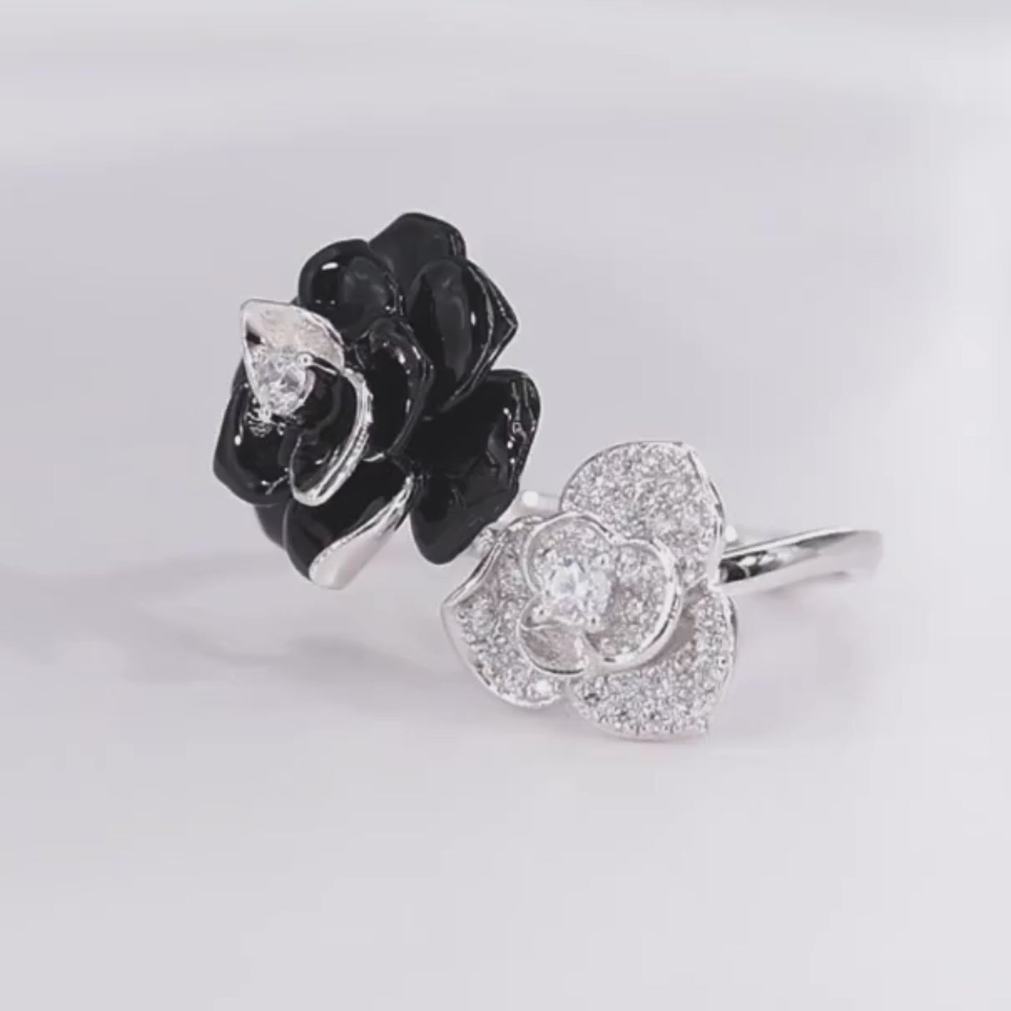 Black and white enamel floral ring with central clear stones in open bypass style


