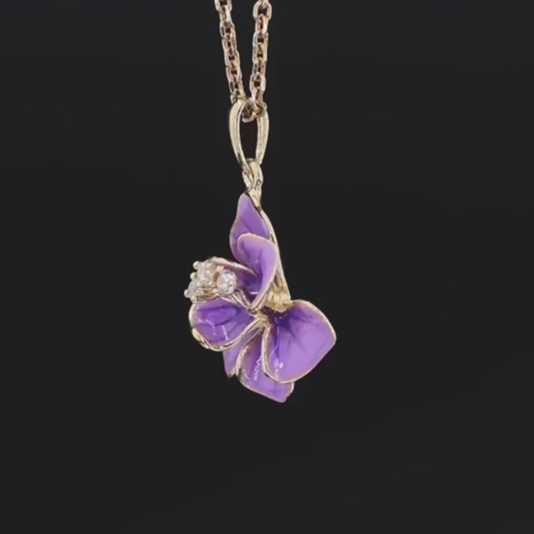 Gold floral pendant with layered violet enamel petals and three small white gemstone accents in the center