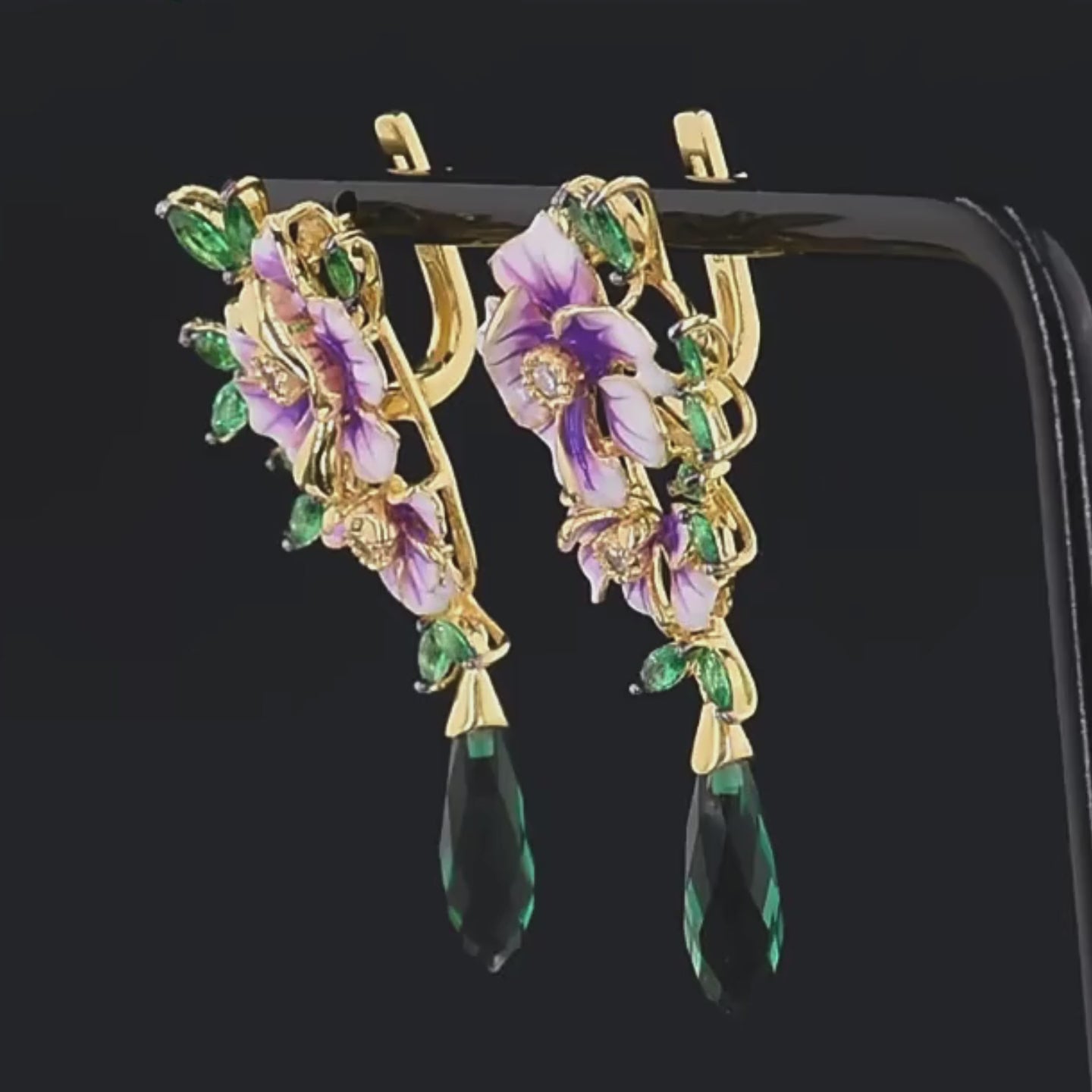 Gold earrings with purple enamel flowers, green marquise leaves, and elongated dark green crystal drops

