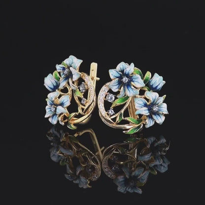 Gold-tone earrings with white and blue enamel flowers and crystal accents

