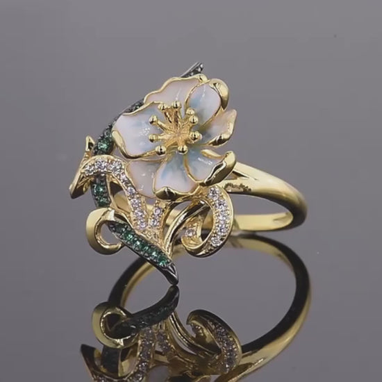 Gold ring with pastel enamel flower, green and clear stones on entwined vine-like details, from the Nastro Verde line.

