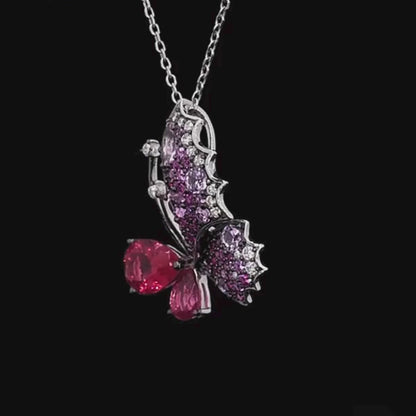 Butterfly ring with sculpted wings in pink and fuchsia gemstones and teardrop-shaped stones forming the body.

